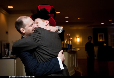 Glasses clang from the dining room signaling a request for the couple to kiss. Rob is in the photobooth room and has to run out in full costume.