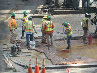Sweeping the yellow sand into the cracks as morter and/or grout.
